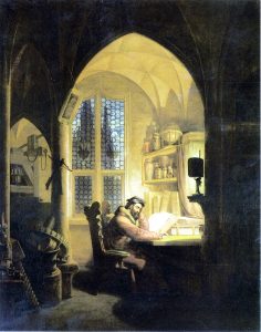 A man sits alone at a wooden desk in a dimly lit, arched room with a high ceiling and detailed stained-glass windows. He is surrounded by books and scientific apparatus, and reads a large book by the light of a single candle. The scene exudes an atmosphere of contemplation and study.